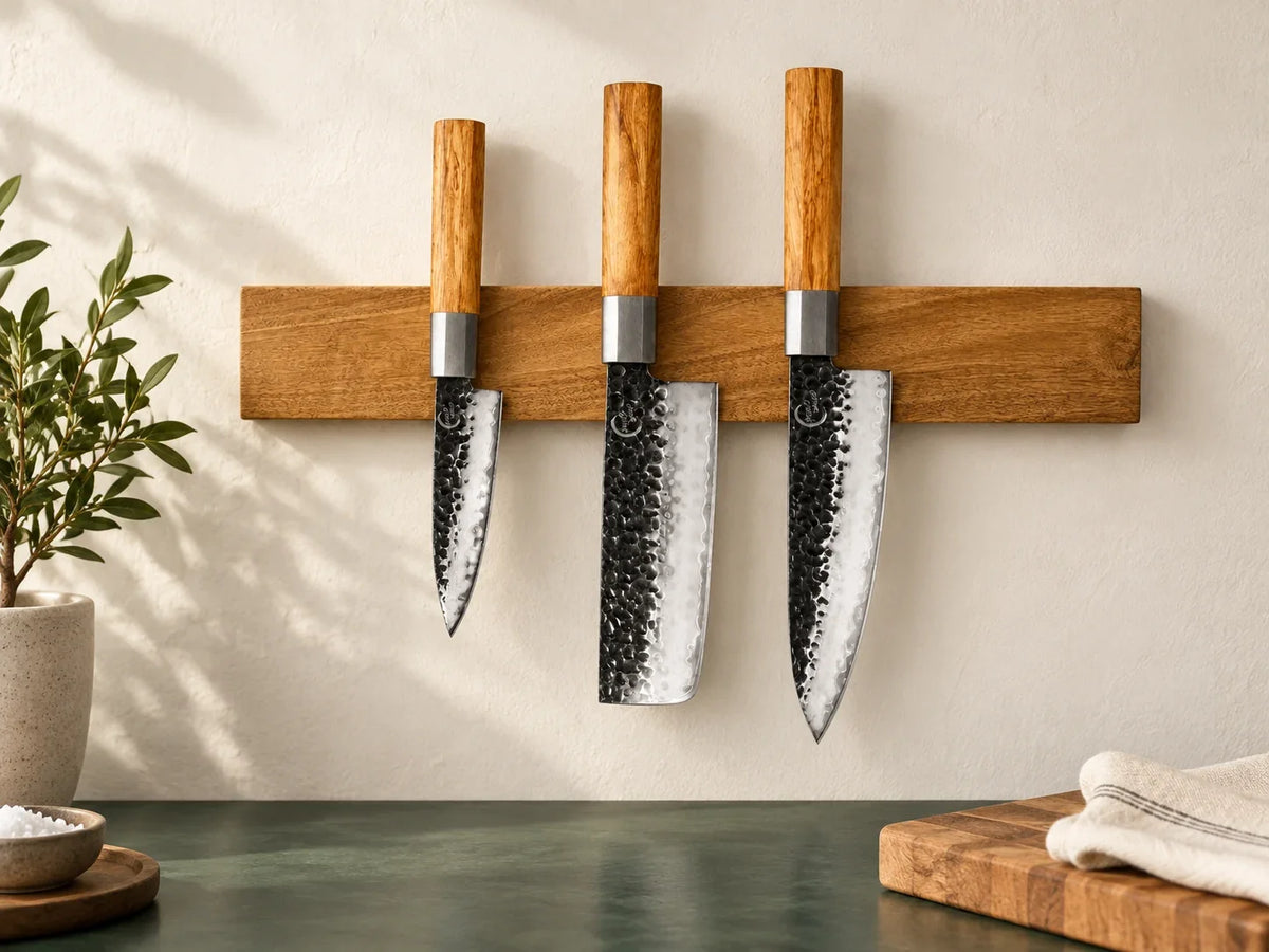 Three Kanso kitchen knives spaced apart on an acacia magnetic knife strip