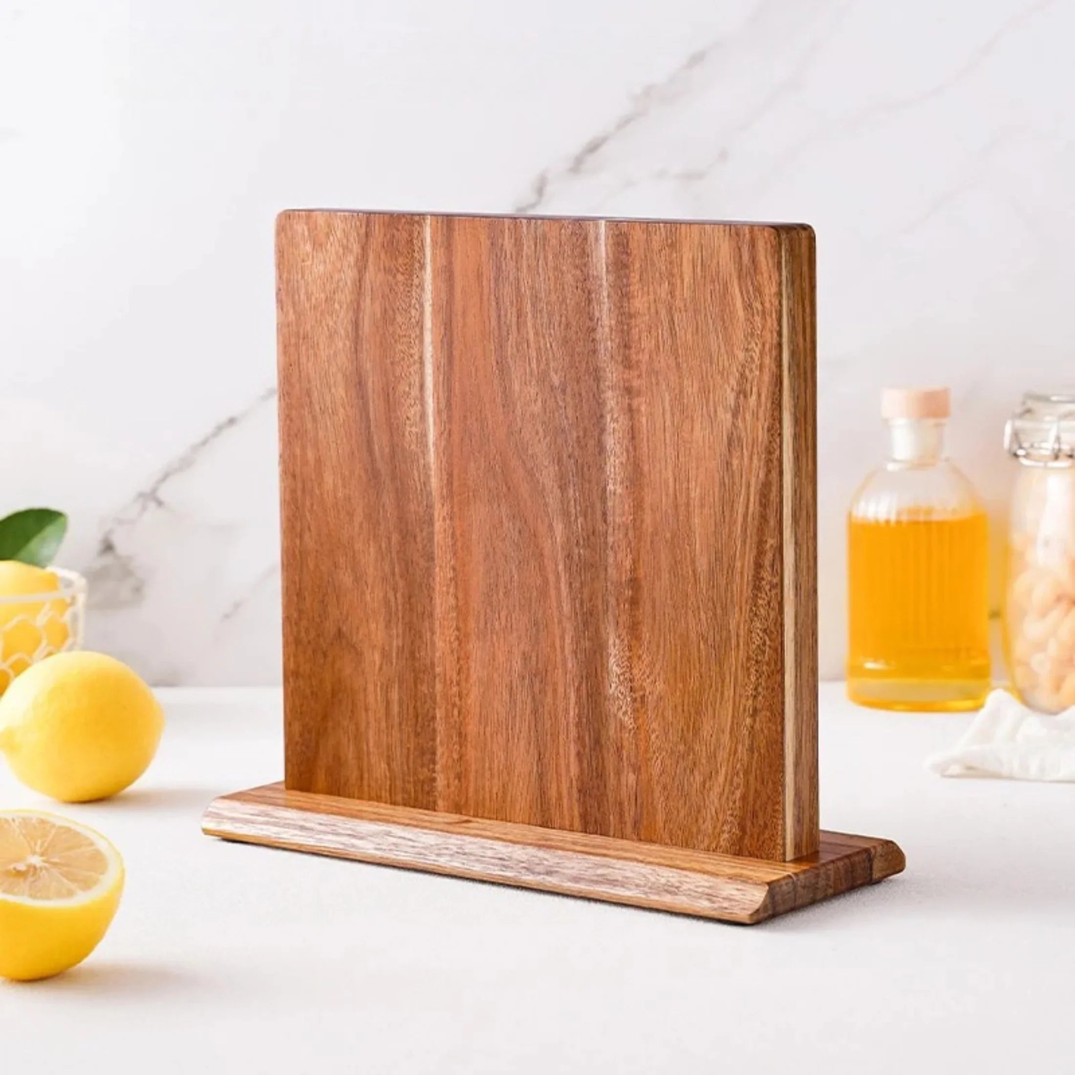 Magnetic wooden knife block on kitchen countertop with lemons and olive oil