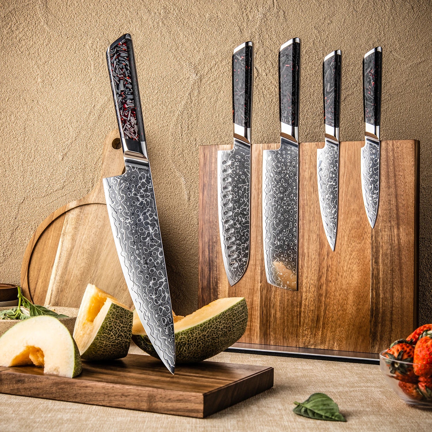 Set of Damascus steel kitchen knives with patterned blades on magnetic wood block, melon slices on cutting board.