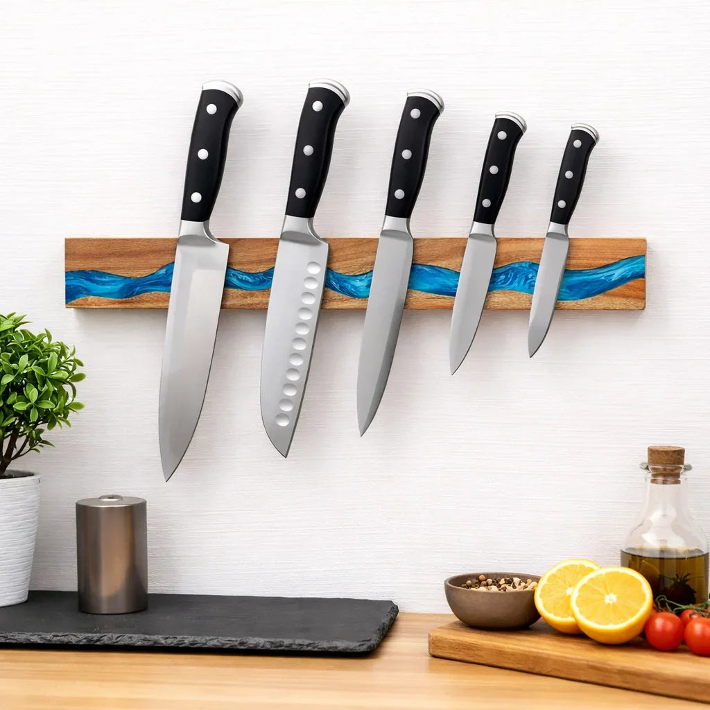Set of kitchen knives with black handles on a wood and resin magnetic wall rack